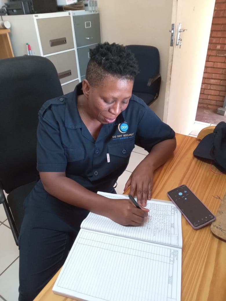 Female security officer writing in register at desk